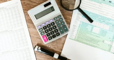 gray calculator and black magnifying glass on brown wooden surface