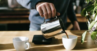person pouring coffee in white ceramic mug