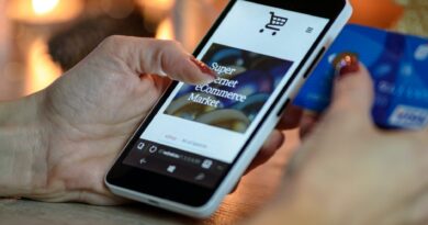 person using black and white smartphone and holding blue card